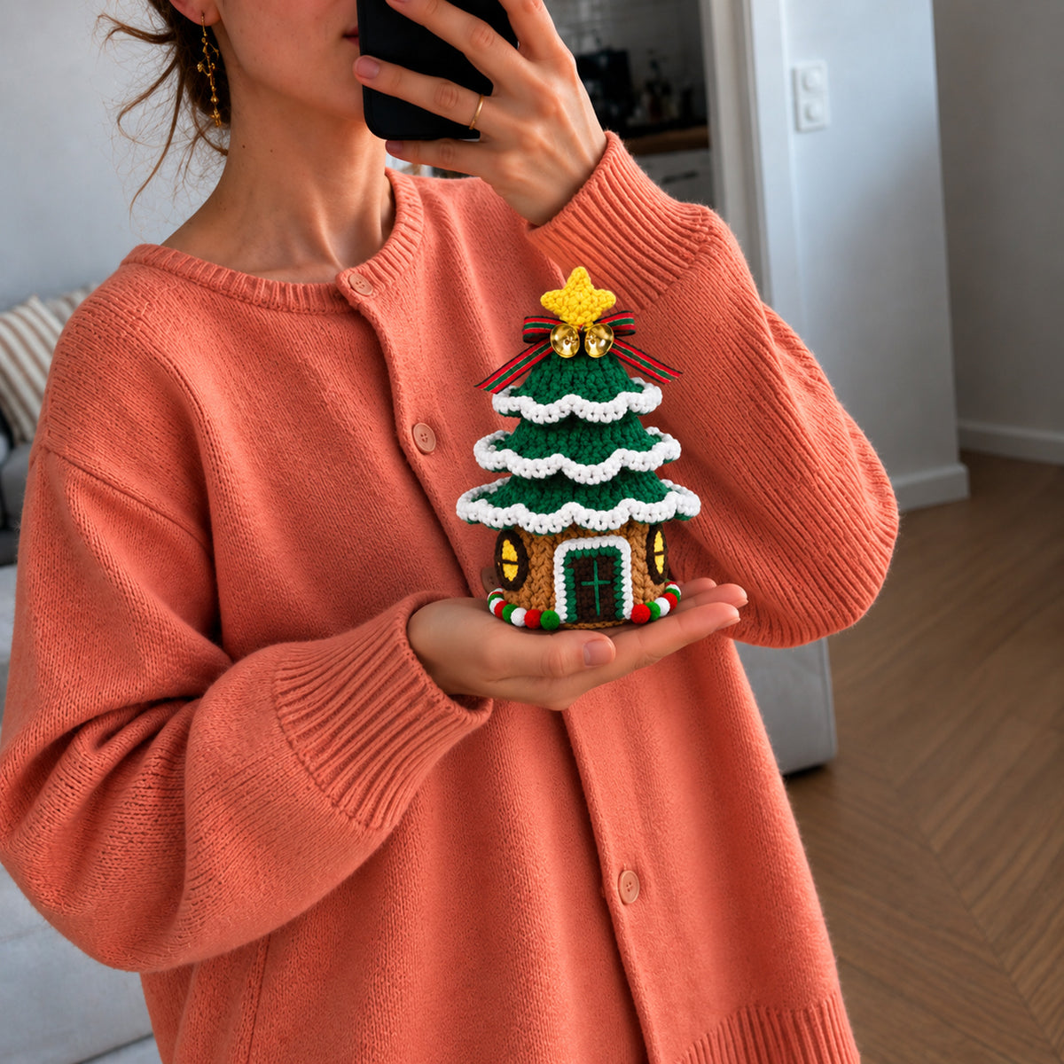 Christmas Tree Cottage: a decorated tree with a small cottage at its base, shown in hand