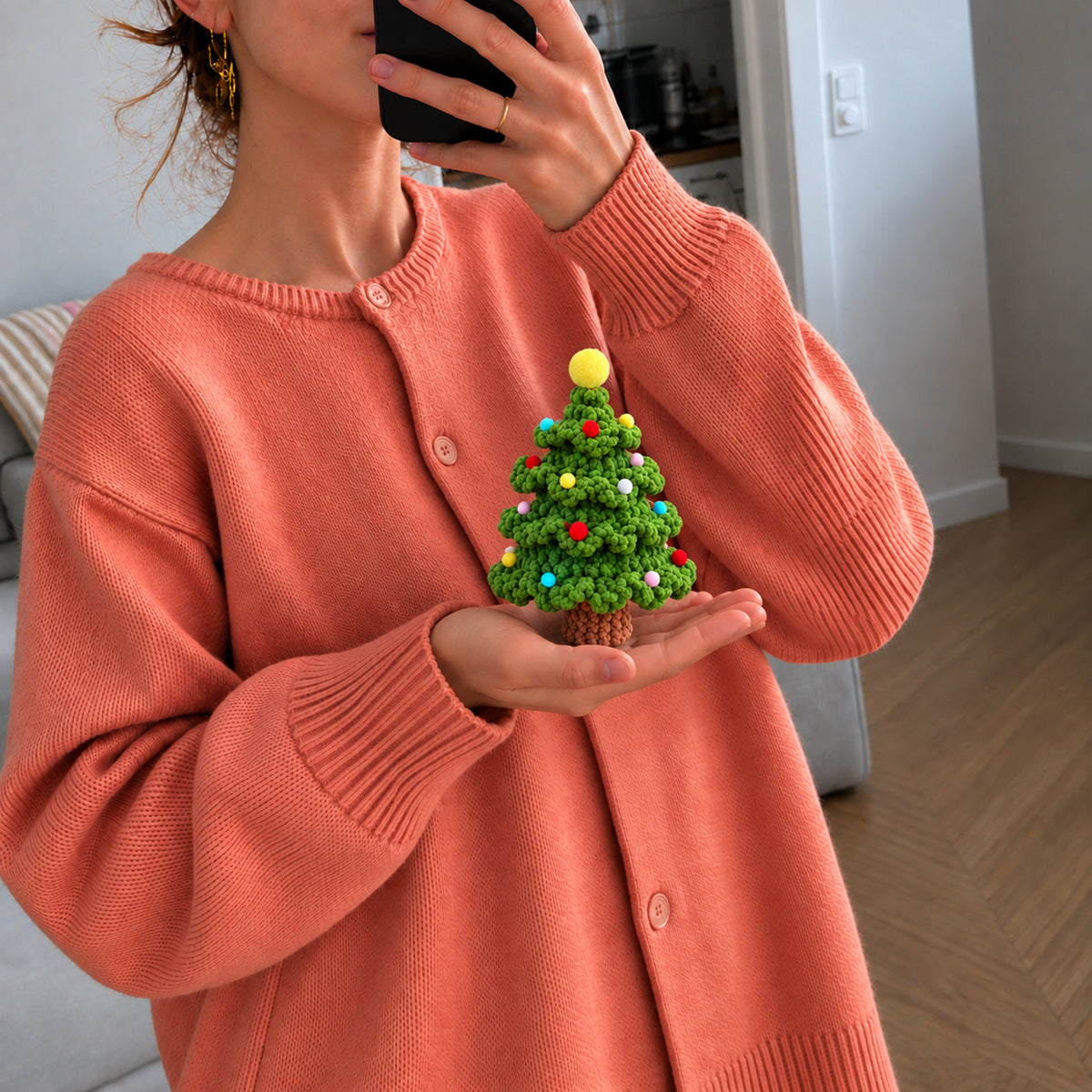 Little Festive Fir: a green fir tree decorated with colourful ornaments, shown in hand
