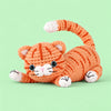 Marmalade Stretch Cat: a marmalade striped cat stretching its paws and curling its tail