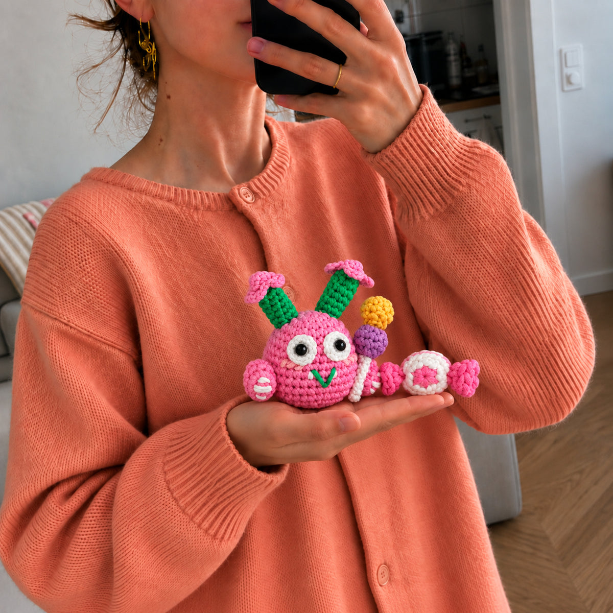 Petal Pop Monster: a pink round monster with colourful flower details, shown in hand