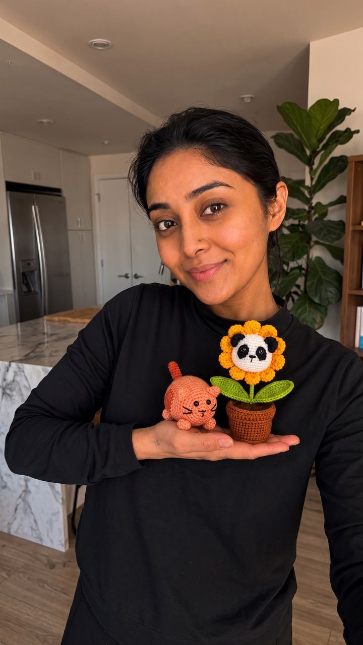 Crafter holding a sunflower and crocheted animal
