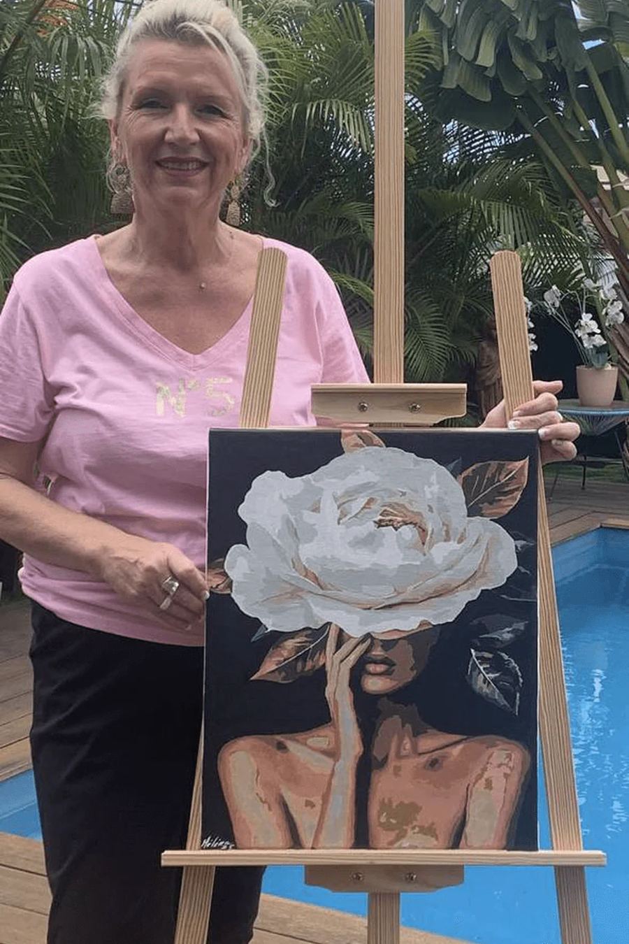 Crafter outdoors beside a floral painting