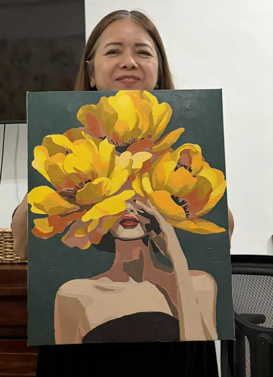 Crafter holding a portrait painting with yellow flowers