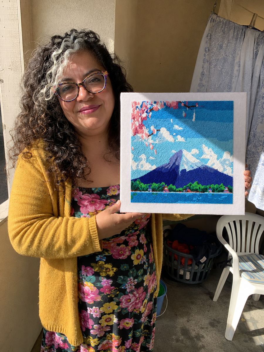 Crafter holding a framed mountain artwork