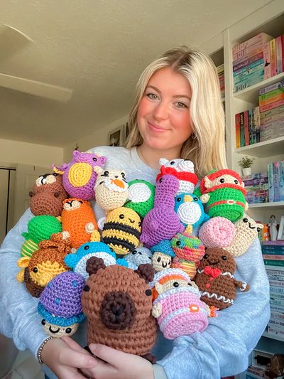 Crafter surrounded by a large collection of crochet projects