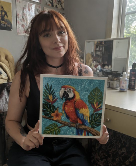 Crafter holding a framed bird artwork