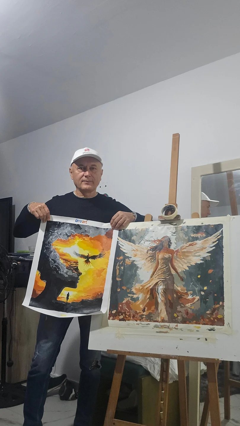 Crafter in a studio showing two paintings
