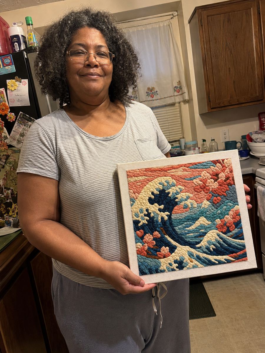 Crafter holding a framed ocean wave artwork