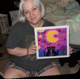 Crafter seated with a colorful cat artwork