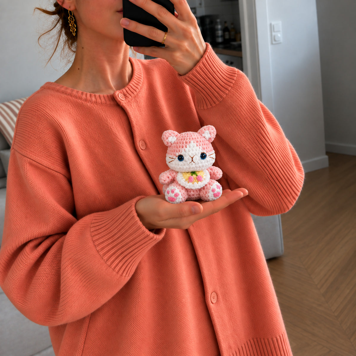 Blossom Bloom Kitty: a blush pink kitten with bright blue eyes and a floral bib, shown in hand