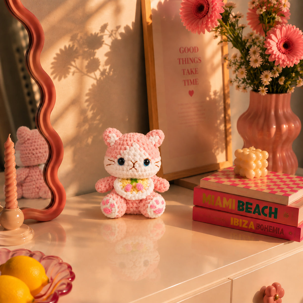 Blossom Bloom Kitty: a blush pink kitten with bright blue eyes and a floral bib, displayed in an interior setting