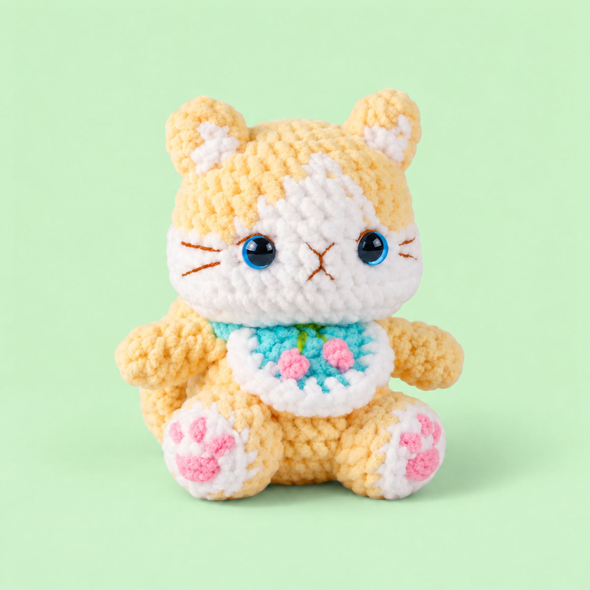 Buttercup Bloom Kitty: a golden yellow kitten with bright blue eyes and a little floral bib