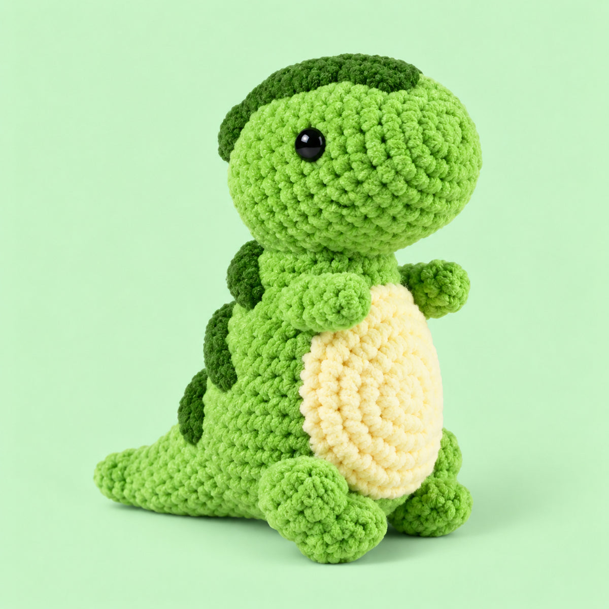 Clover Little Dino: a green standing dinosaur with a cream belly