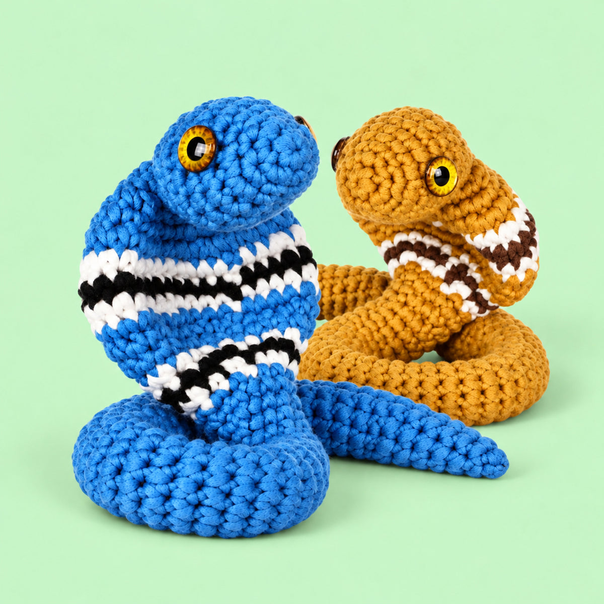 Cobra Charm Duo: blue and ochre cobras with striped markings and rounded faces