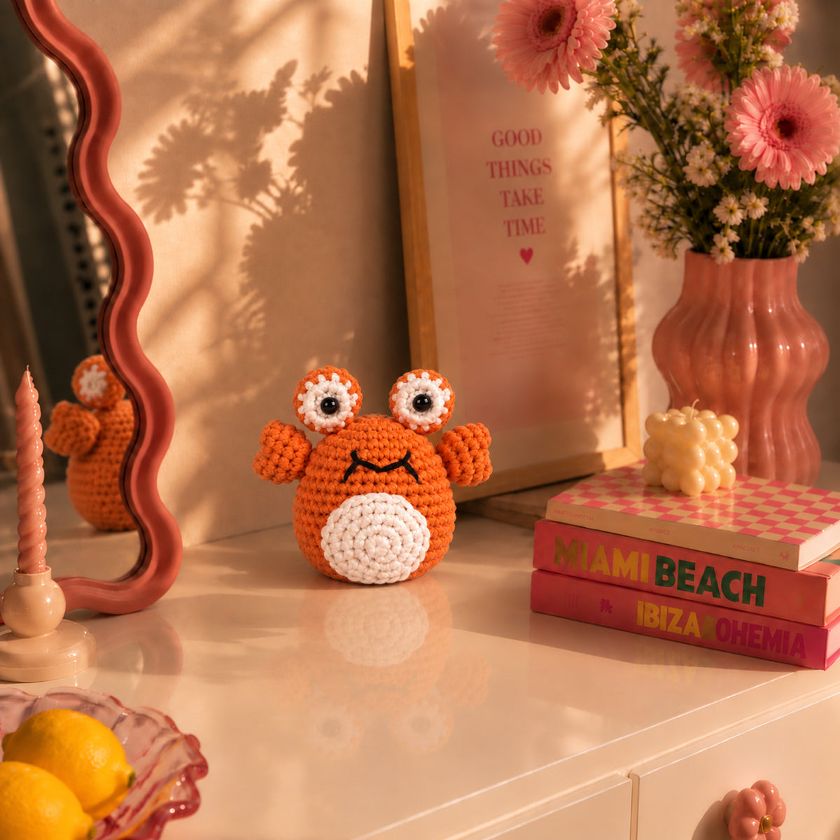 Coral Pop Crab: an orange crab with tall eyes and small raised claws, displayed in an interior setting