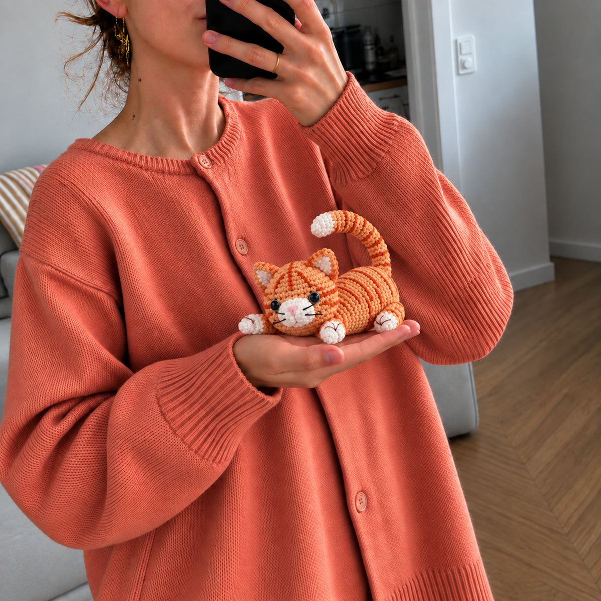 Marmalade Stretch Cat: a marmalade striped cat stretching its paws and curling its tail, shown in hand