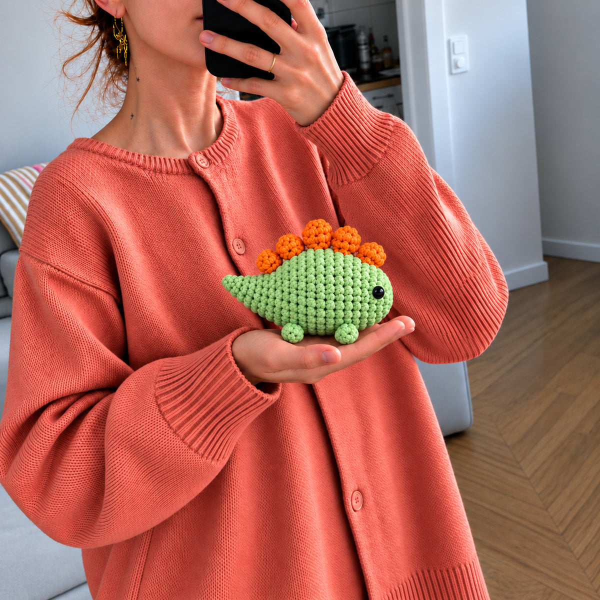 Meadow Stegosaurus: a green dinosaur with bright orange plates along its back, shown in hand