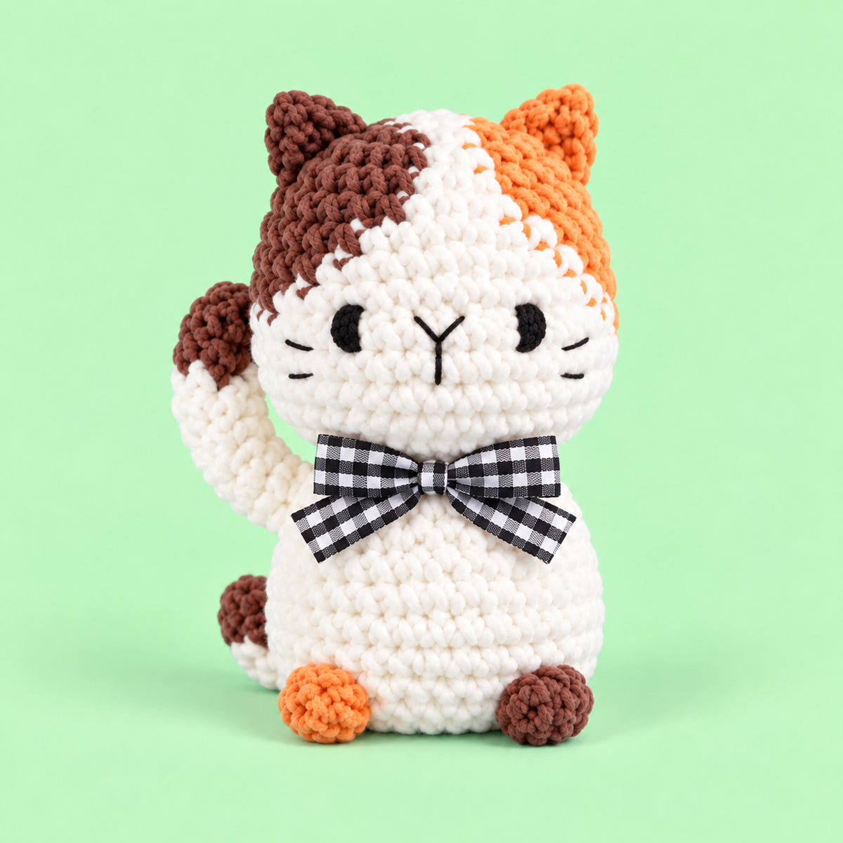 Patchwork Bow Cat: a calico cat with orange and brown patches and a checked bow