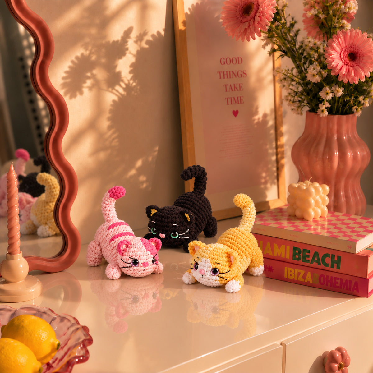 Playful Paw Trio: black, pink and yellow cats in a playful stretching pose, displayed in an interior setting