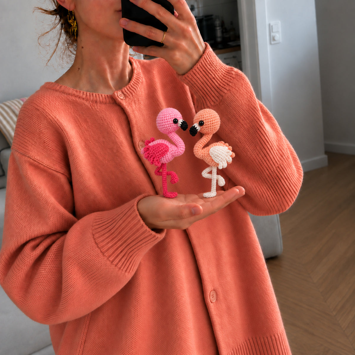 Rosy Lagoon Flamingos: pink and peach flamingos with curved necks and delicate legs, shown in hand