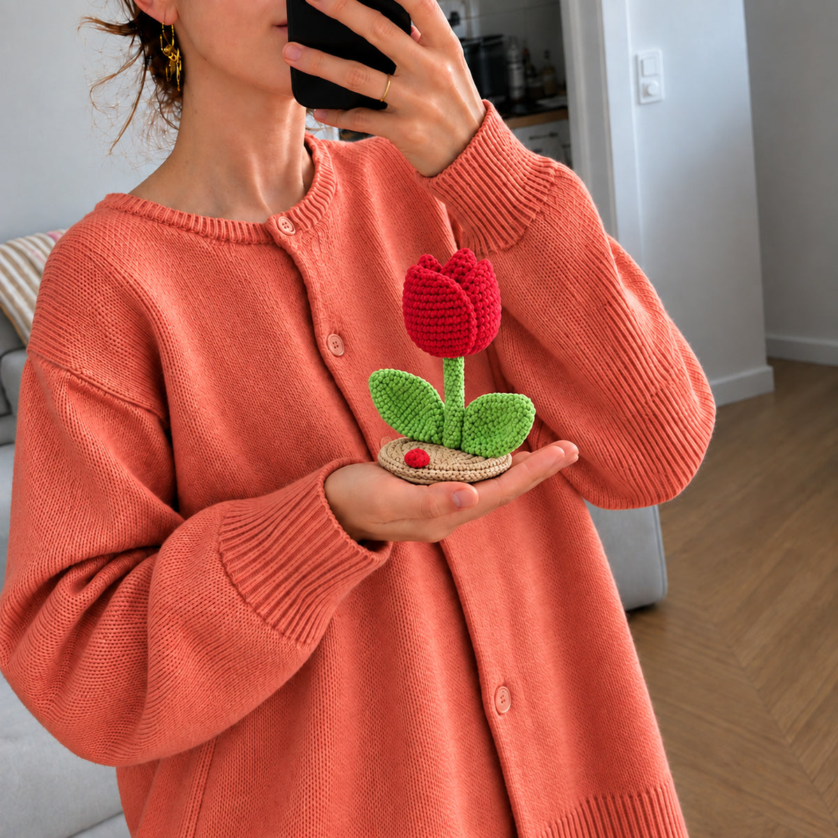 Ruby Tulip: a red tulip with green leaves on a small base, shown in hand