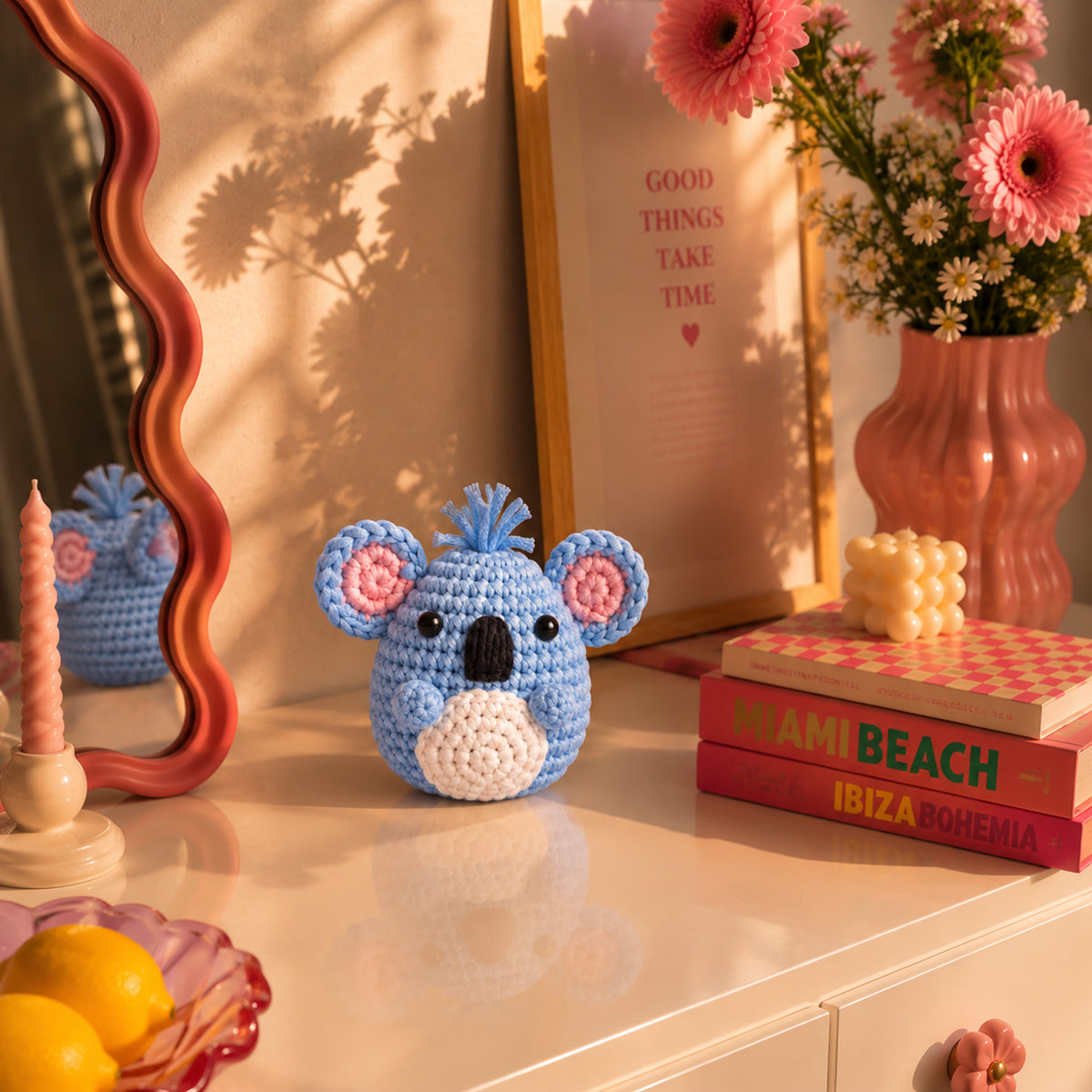 Sky Blue Koala: a sky blue koala face with pink ears and a little tuft on top, displayed in an interior setting
