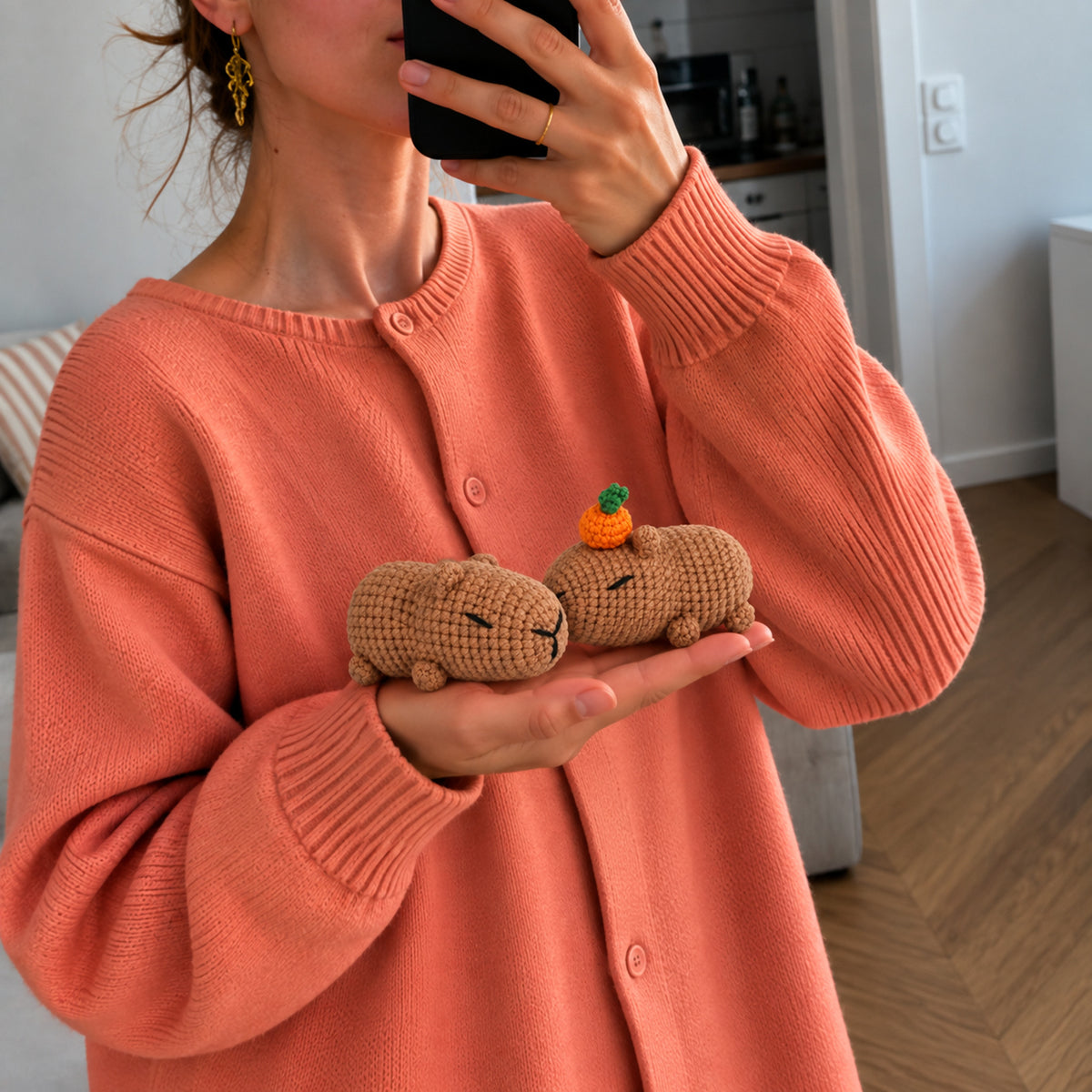 Sleepy Citrus Capybaras: resting capybaras with tiny citrus details, shown in hand