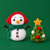 Snow Day Companions: a snowman in a green scarf beside a decorated tree