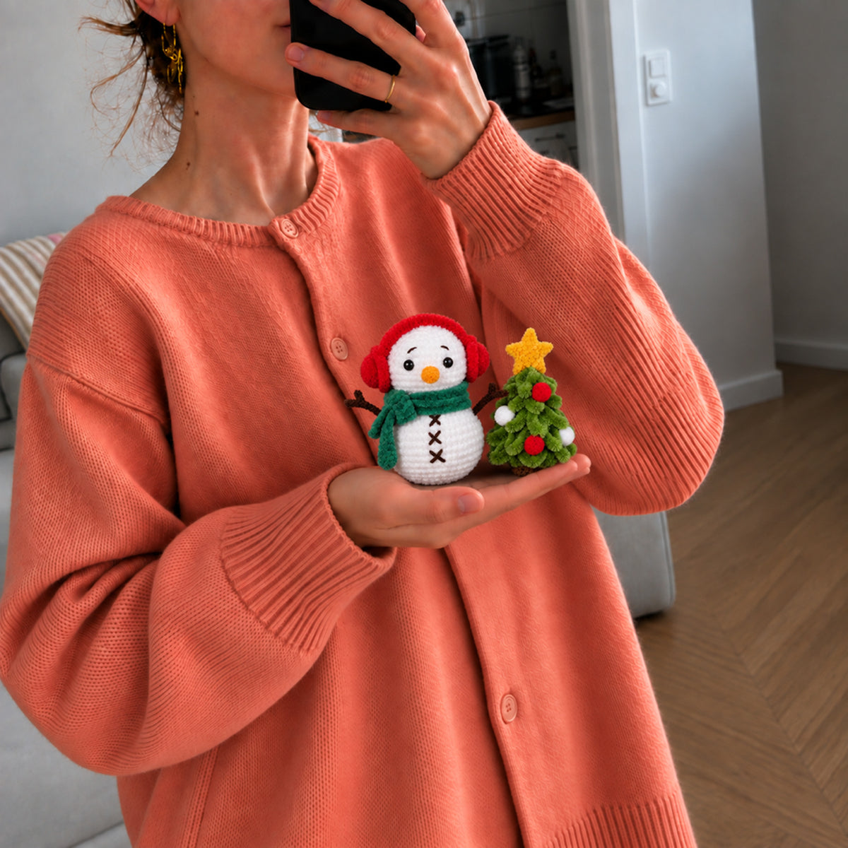 Snow Day Companions: a snowman in a green scarf beside a decorated tree, shown in hand