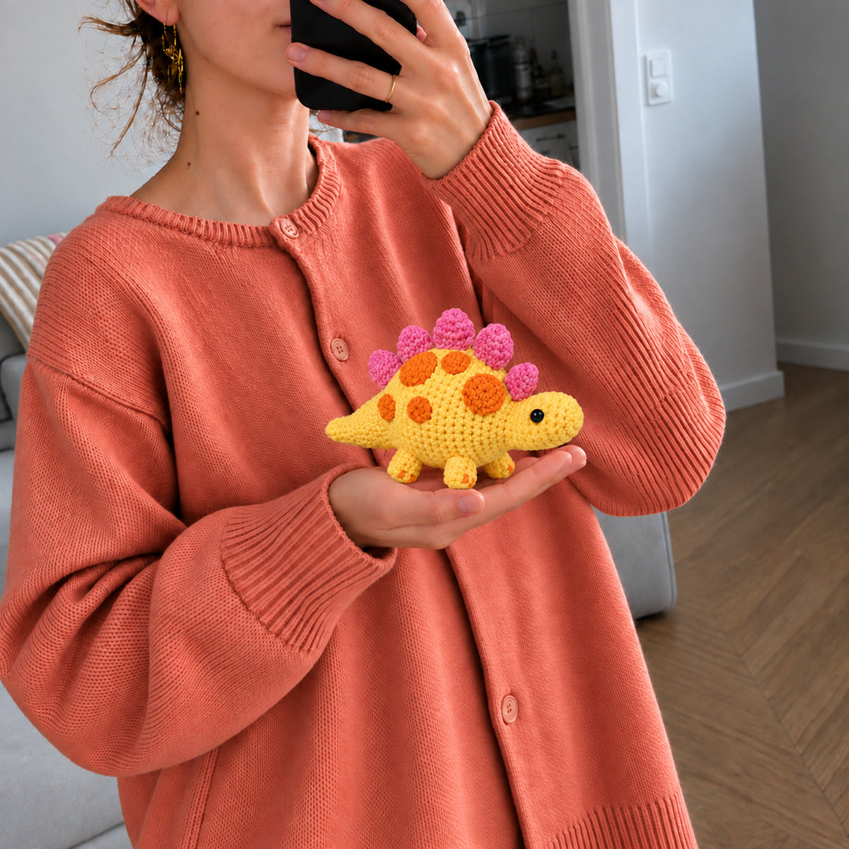 Sunshine Stegosaurus: a yellow dinosaur with bright orange and pink back plates, shown in hand