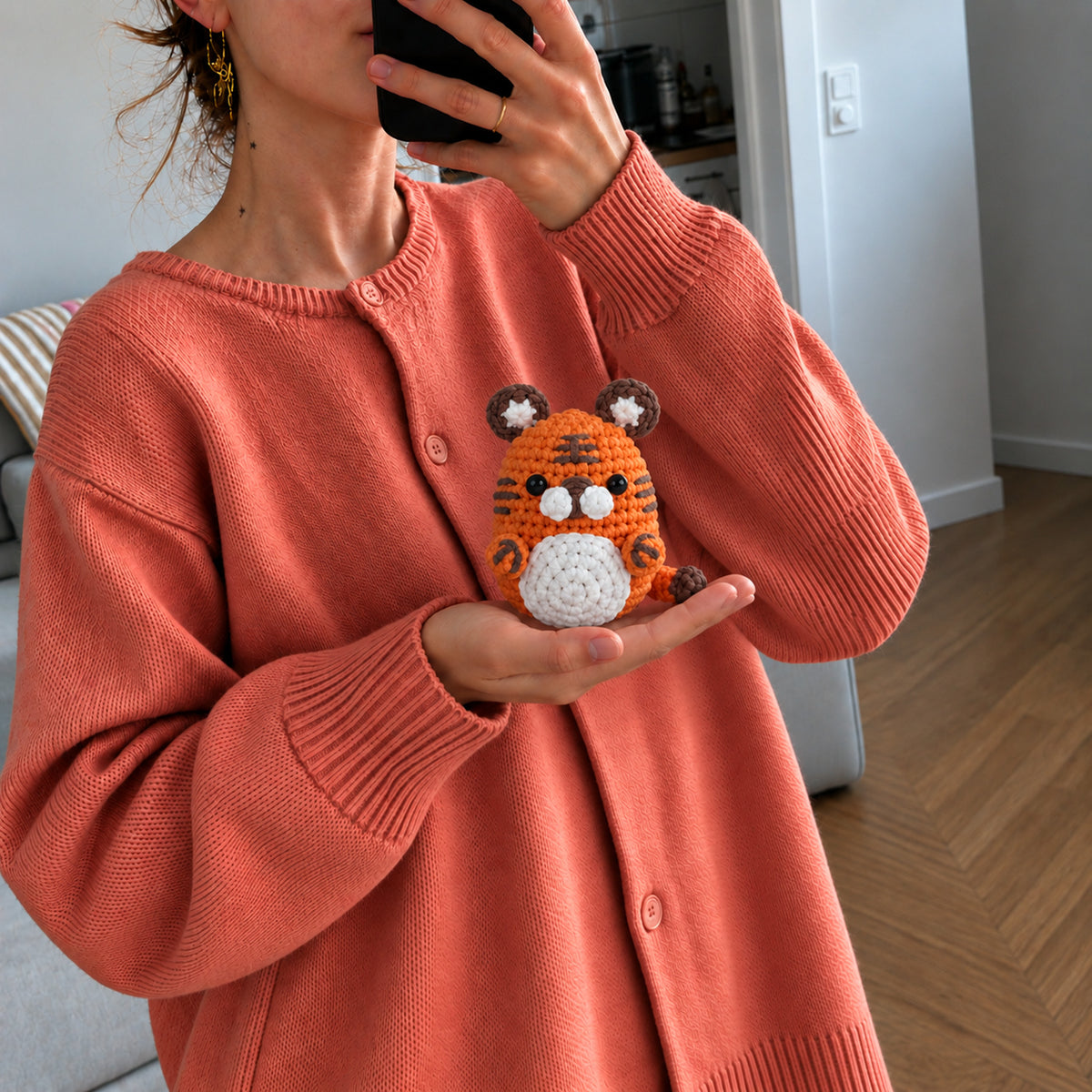 Tangerine Tiger: a bright orange tiger with dark stripes and rounded ears, shown in hand