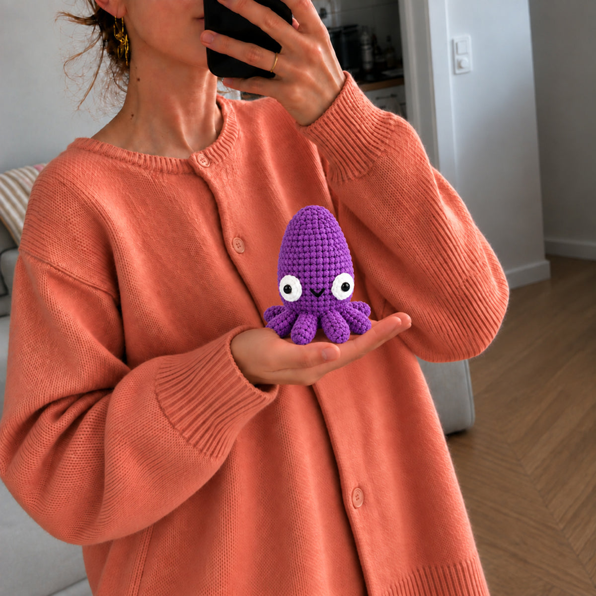 Violet Tide Cuttlefish: a violet cuttlefish with a rounded head and smiling face, shown in hand