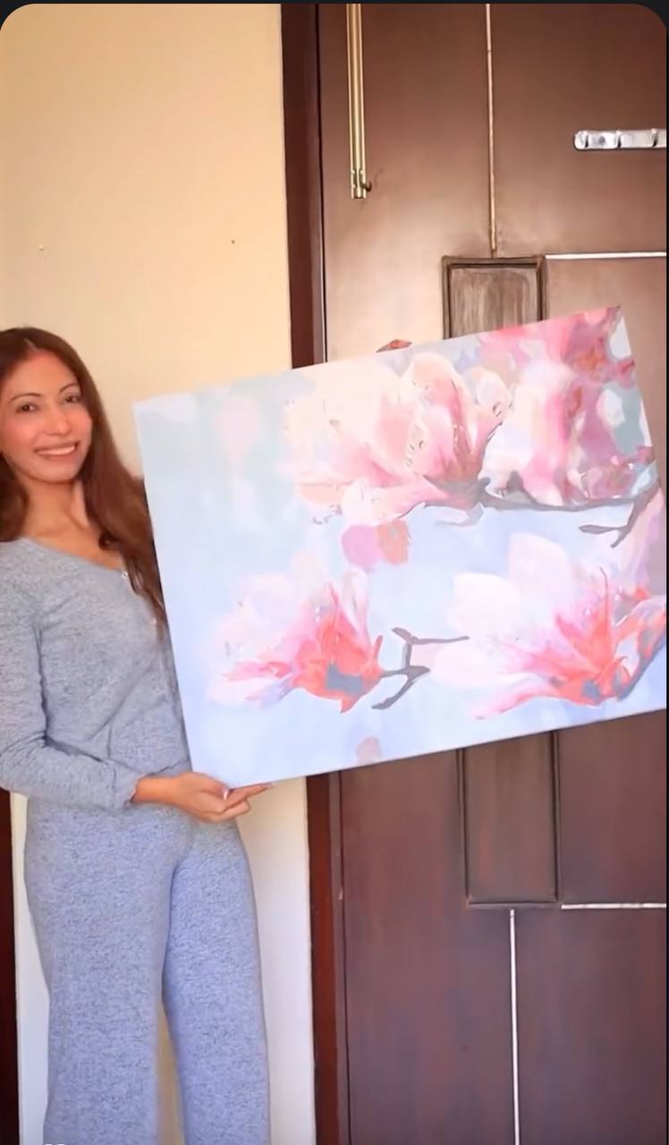 Painter showing a wide pink floral canvas