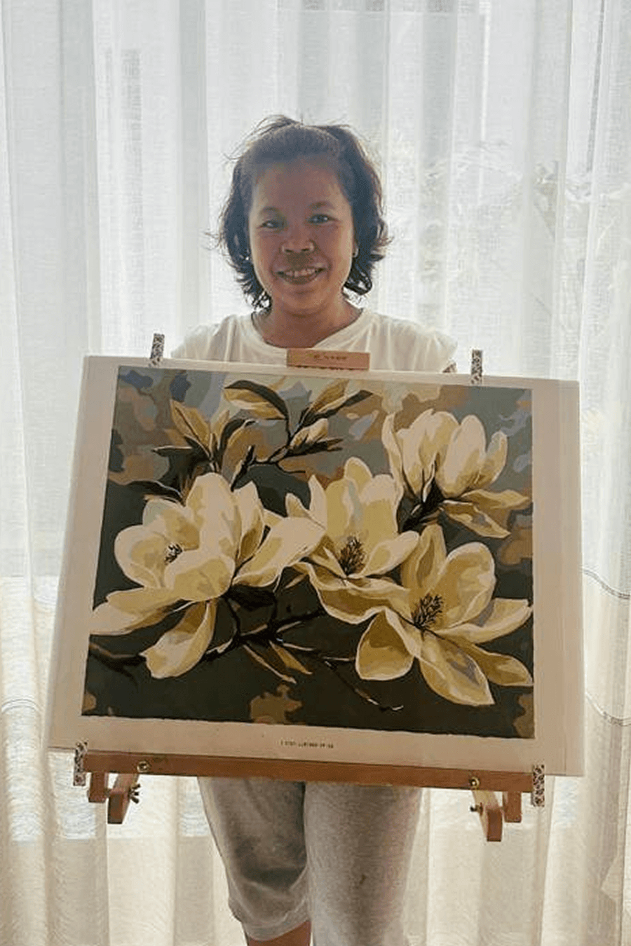 Painter presenting a large botanical artwork